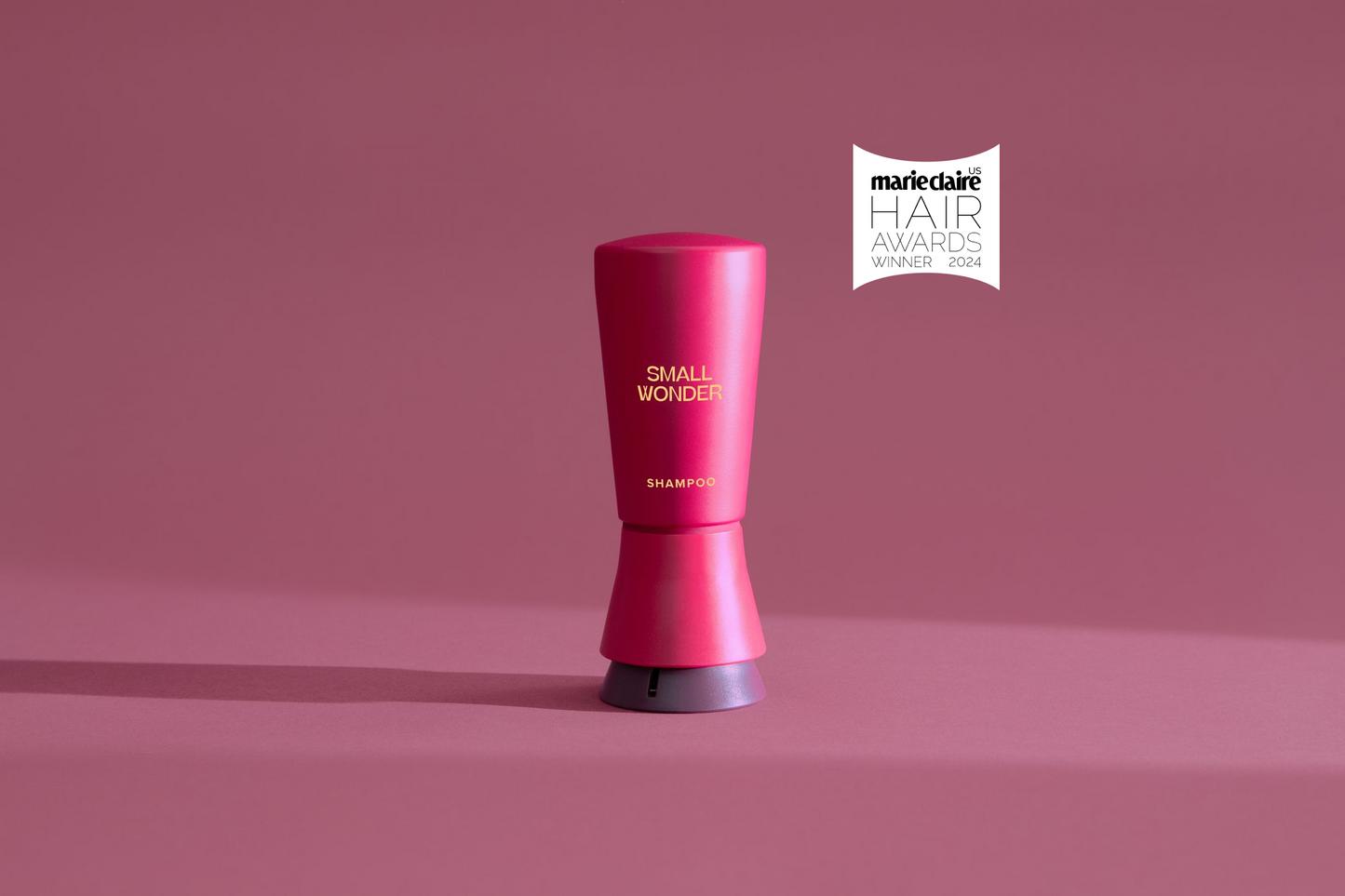 Red Small Wonder Shampoo bottle with Marie Claire Hair Award logo on pink background