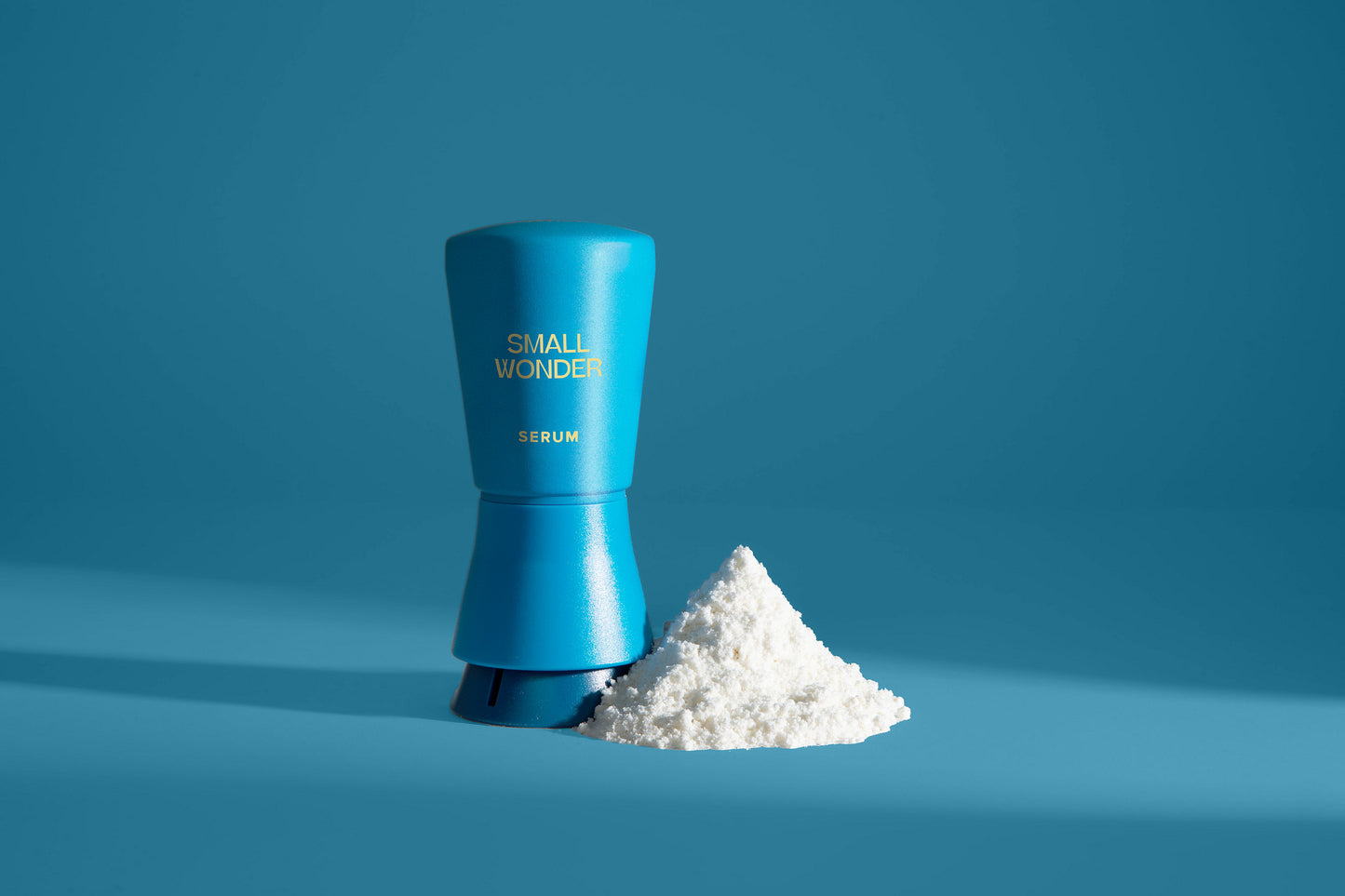 Blue container labeled 'Small Wonder' with white powder on a blue background
