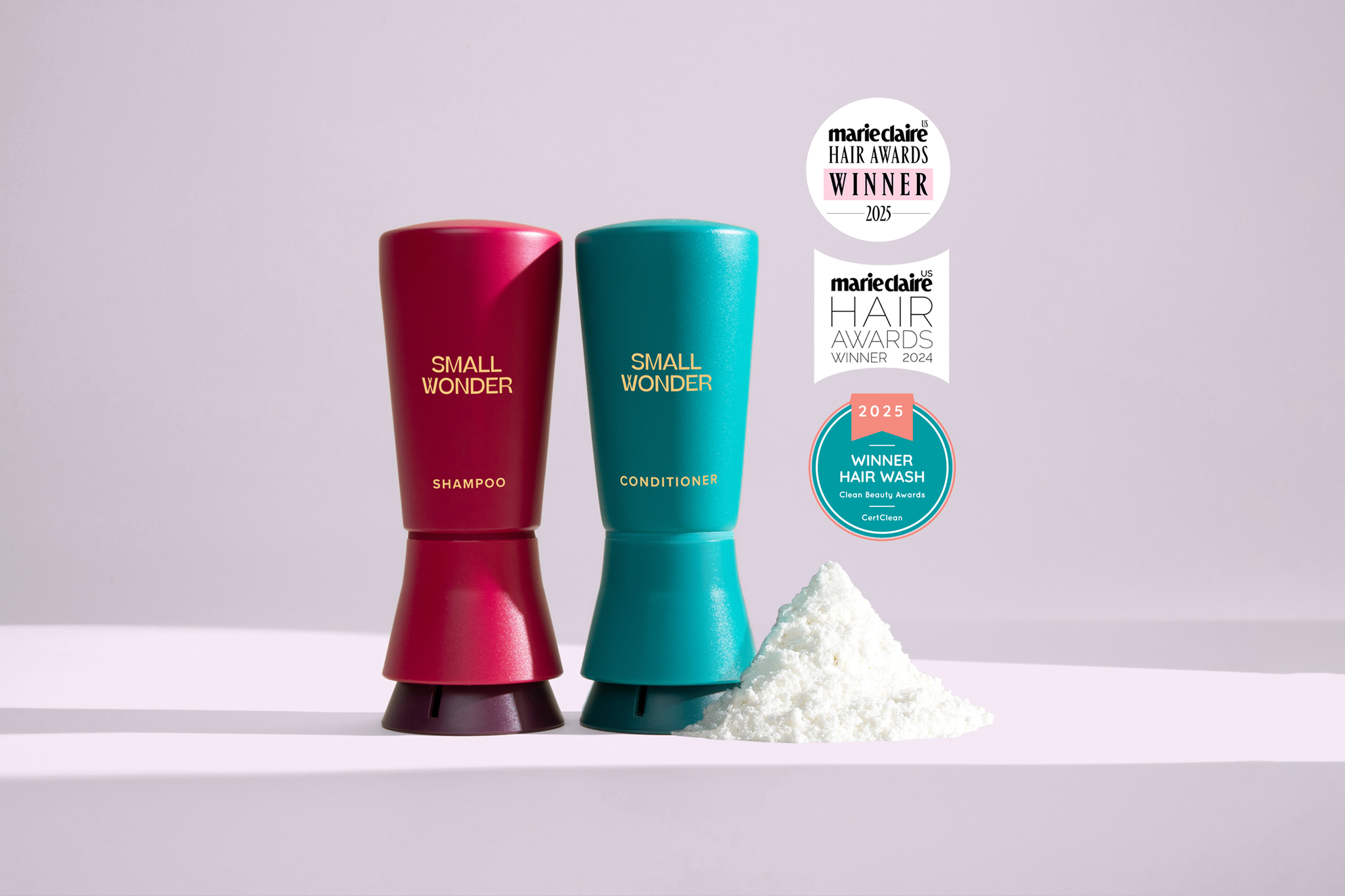 Red and teal 'Small Wonder' shampoo and conditioner bottles with awards on a light purple background visibility=hidden