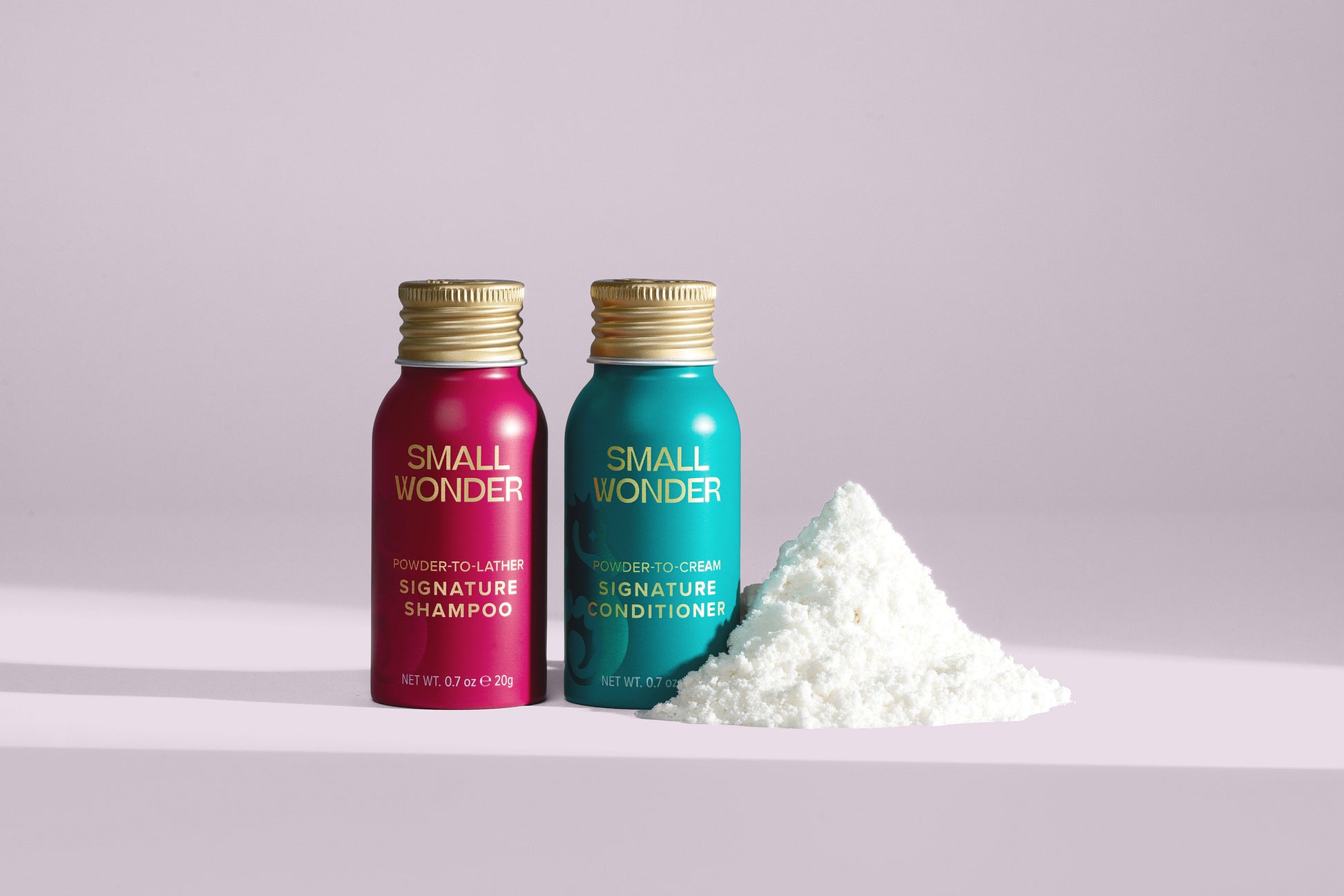 Two bottles of 'Small Wonder' shampoo and conditioner with a pile of white powder on a light purple background.